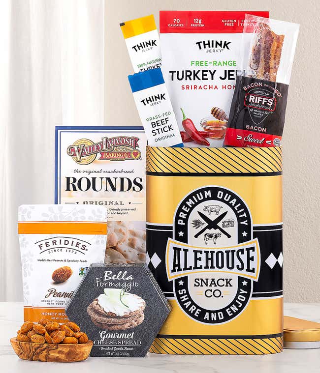 This Alehouse-themed gift tin features a sleek black and yellow design filled with gourmet snacks. It includes Think Jerky's Turkey Jerky and Beef Sticks, Riffs Bacon, Valley Lahvosh crackers, Feridies Peanuts, and Bella Formaggio Cheese Spread. &amp;#8203;&amp;#