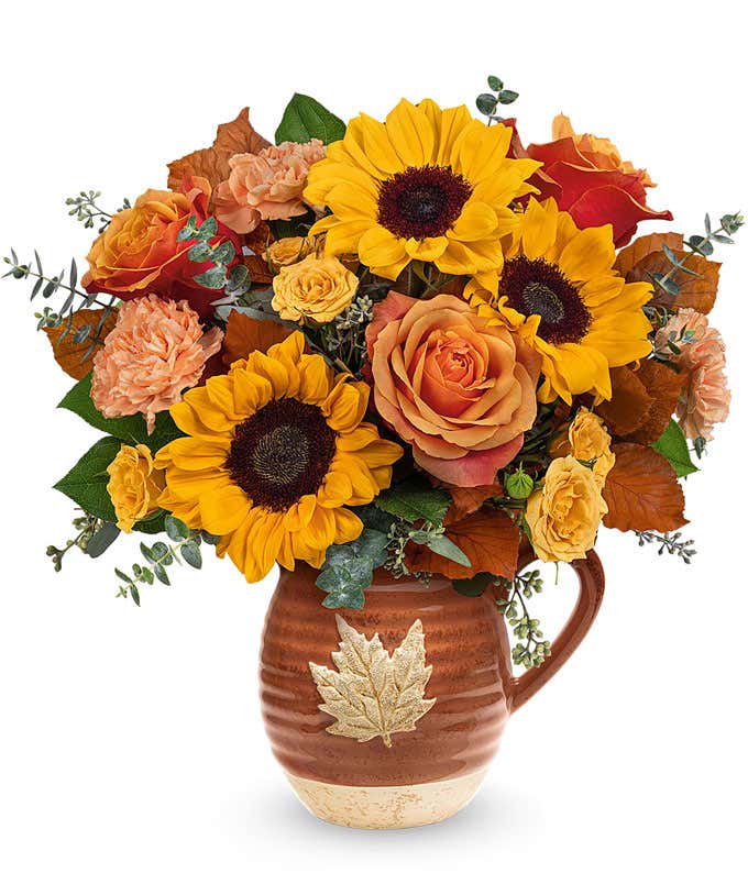 Orange and yellow roses, peach carnations, yellow sunflowers, brown copper beech, seeded & spiral eucalyptus, 
